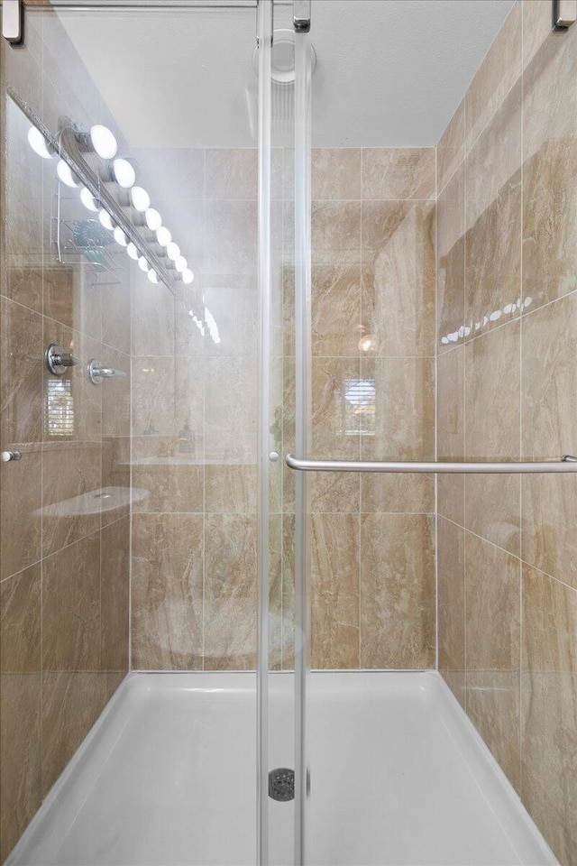 bathroom featuring a shower with door