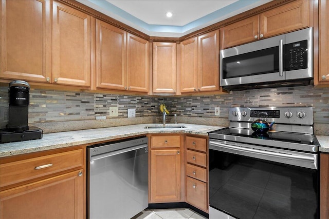 kitchen featuring light tile patterned flooring, sink, tasteful backsplash, stainless steel appliances, and light stone countertops