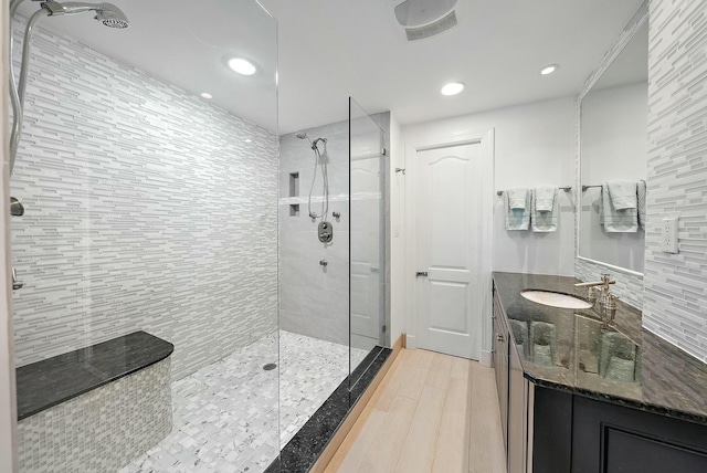 bathroom with vanity, hardwood / wood-style floors, and a tile shower