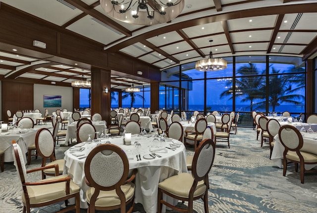 dining area with coffered ceiling, expansive windows, and a chandelier