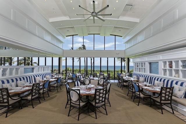 interior space with a water view, ceiling fan, and carpet