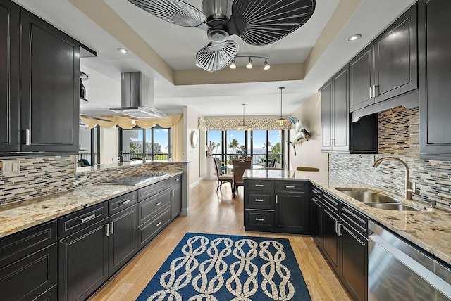 kitchen with sink, dishwasher, a tray ceiling, black electric cooktop, and kitchen peninsula