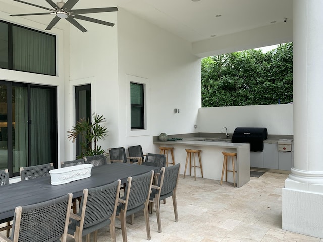 view of patio featuring grilling area, exterior kitchen, ceiling fan, and an outdoor wet bar