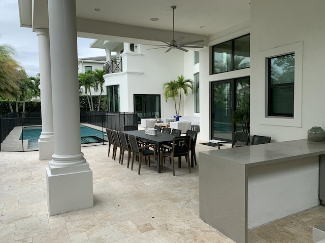 view of patio / terrace with ceiling fan, a fenced in pool, and a balcony