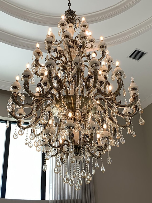 interior details featuring a notable chandelier and crown molding