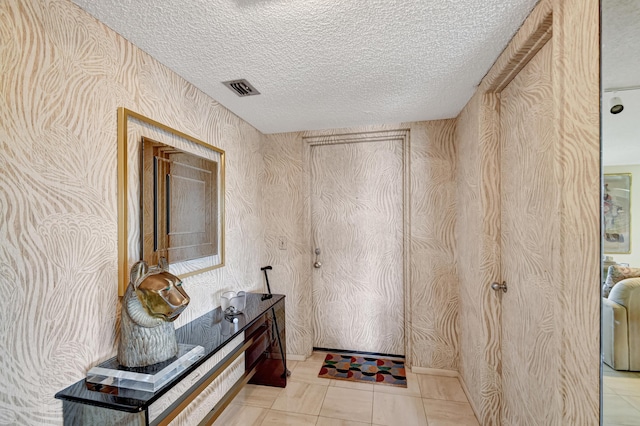 interior space with light tile patterned floors and a textured ceiling