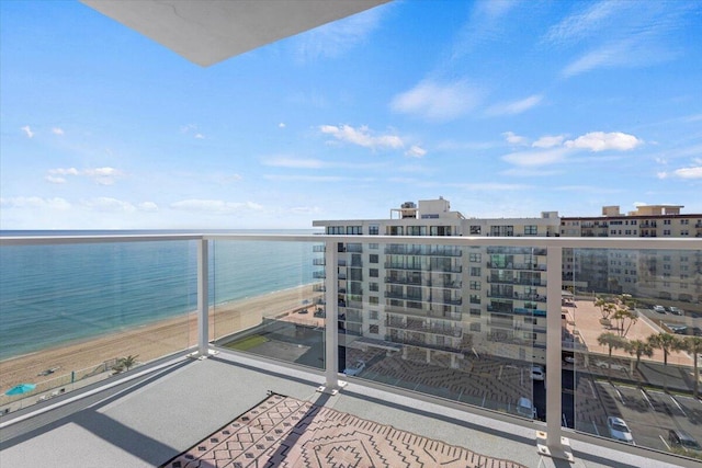 balcony featuring a water view and a view of the beach