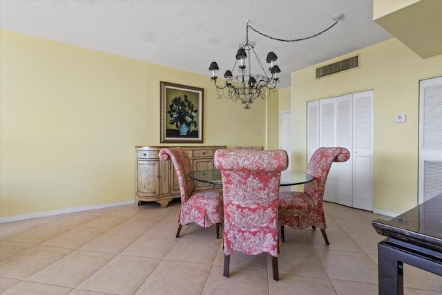 dining space with light tile patterned floors, a textured ceiling, and a notable chandelier