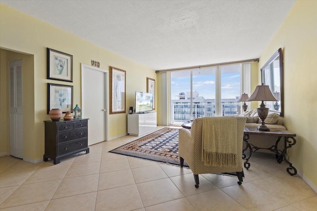 tiled living room with expansive windows and a textured ceiling