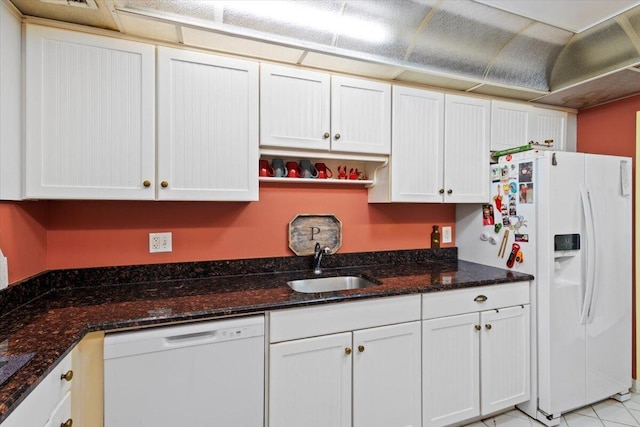 kitchen featuring white cabinetry, sink, dark stone countertops, and white appliances