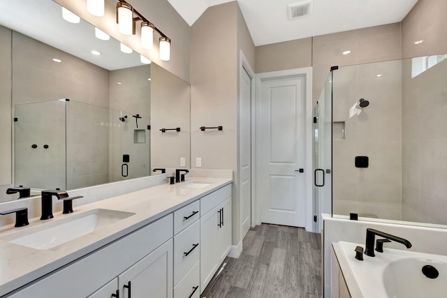 bathroom featuring hardwood / wood-style flooring, vanity, and shower with separate bathtub