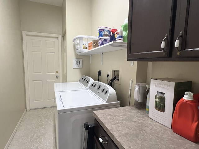 clothes washing area with cabinets and washing machine and dryer