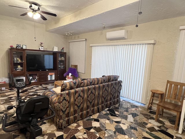 living room with ceiling fan, a textured ceiling, and an AC wall unit