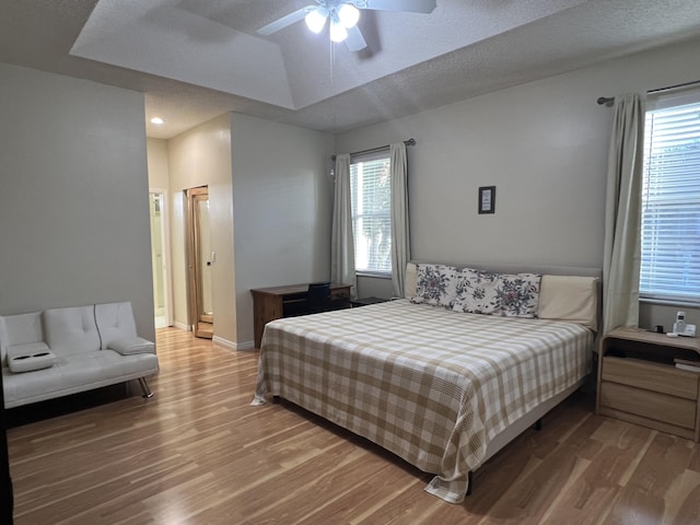 bedroom featuring wood-type flooring, ceiling fan, and a textured ceiling