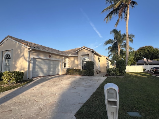 ranch-style home with a garage and a front lawn