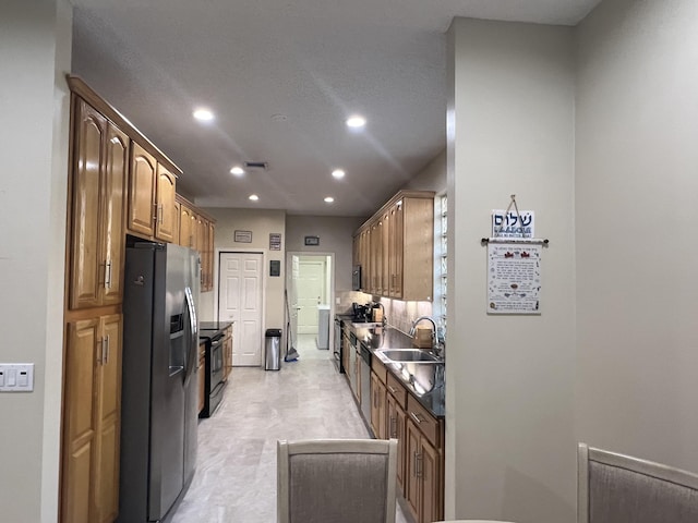 kitchen with electric stove, stainless steel fridge with ice dispenser, tasteful backsplash, and sink