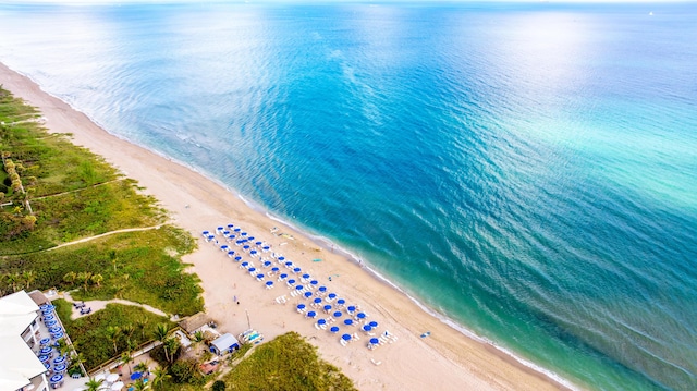 birds eye view of property featuring a water view and a beach view