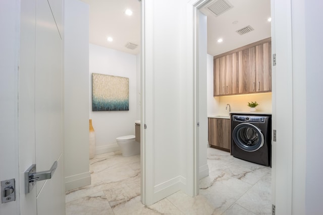 bathroom featuring toilet, vanity, and washer / clothes dryer