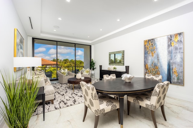 dining room featuring a wall of windows and a raised ceiling