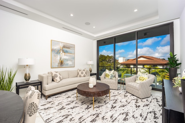 living room with expansive windows and a raised ceiling