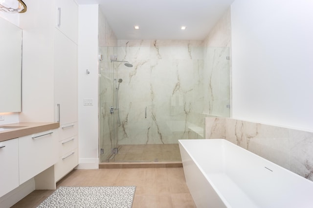 bathroom with vanity, tile patterned floors, and plus walk in shower