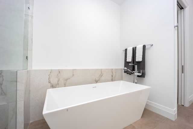 bathroom with a bathing tub and tile walls