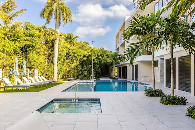 view of pool with a patio area and a hot tub