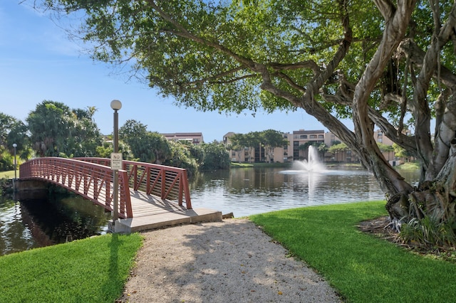 view of dock with a water view and a yard