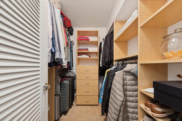 walk in closet with light tile patterned floors