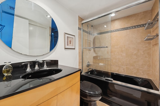 full bathroom with bath / shower combo with glass door, vanity, and toilet