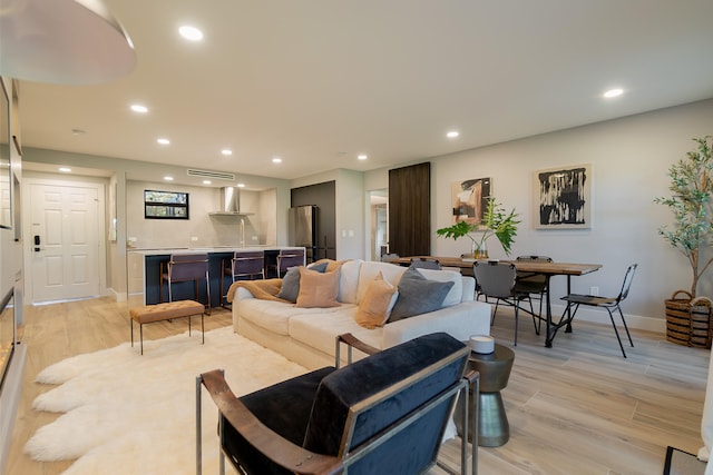 living room with bar and light wood-type flooring