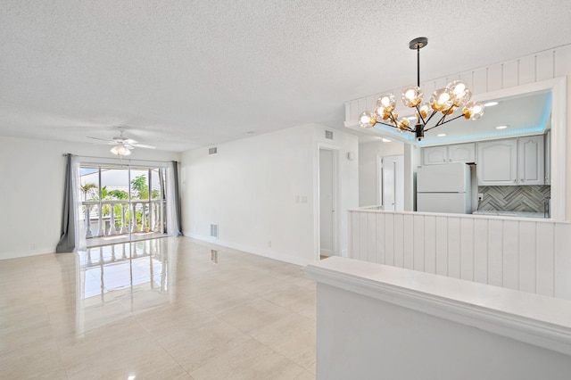148 Yacht Club Dr Unit 12, North Palm Beach, FL 33408 - unfurnished living room featuring a textured ceiling, a chandelier, ceiling fan, and light tile patterned flooring