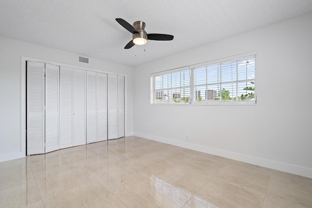 148 Yacht Club Dr Unit 12, North Palm Beach, FL 33408 - unfurnished bedroom with a closet, a textured ceiling, a ceiling fan, and tile patterned flooring