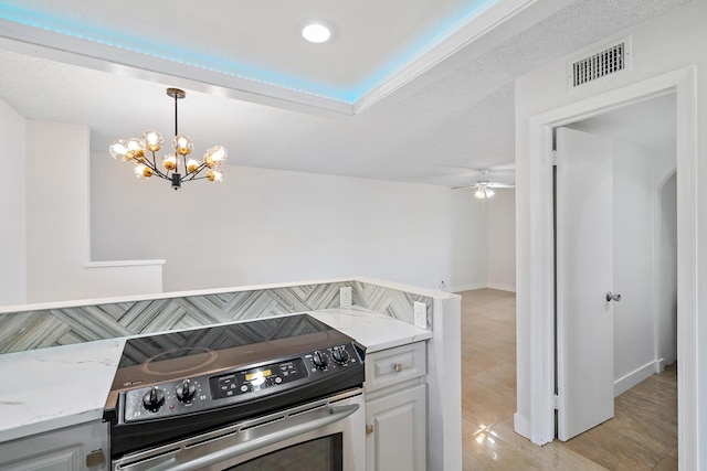 148 Yacht Club Dr Unit 12, North Palm Beach, FL 33408 - kitchen with stainless steel electric stove, a chandelier, light stone counters, ceiling fan, and pendant lighting