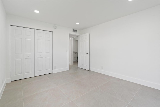 unfurnished bedroom featuring a closet and light tile patterned floors