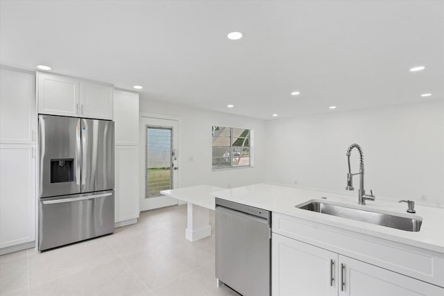 kitchen featuring white cabinetry, stainless steel appliances, sink, and light tile patterned floors