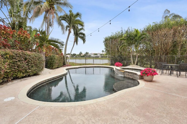 view of pool with an in ground hot tub, a patio, and a water view