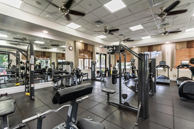 exercise room with ceiling fan and a paneled ceiling