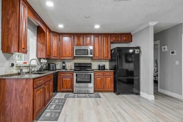 kitchen featuring sink, dark stone countertops, decorative backsplash, black appliances, and light wood-type flooring