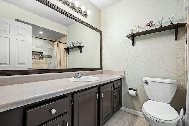 bathroom featuring walk in shower, vanity, and toilet