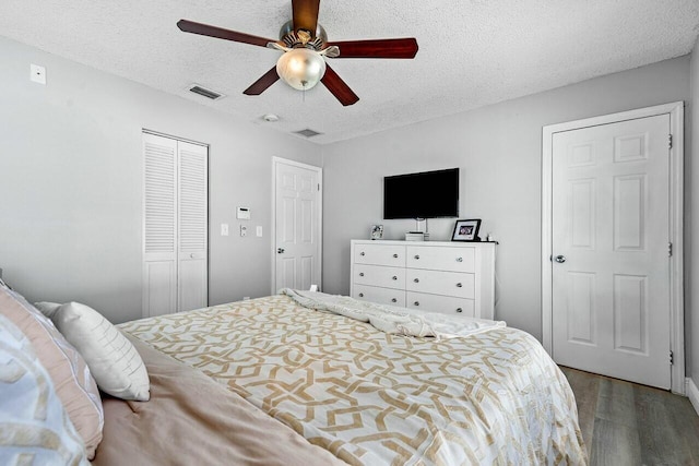 bedroom featuring hardwood / wood-style flooring, ceiling fan, a textured ceiling, and a closet