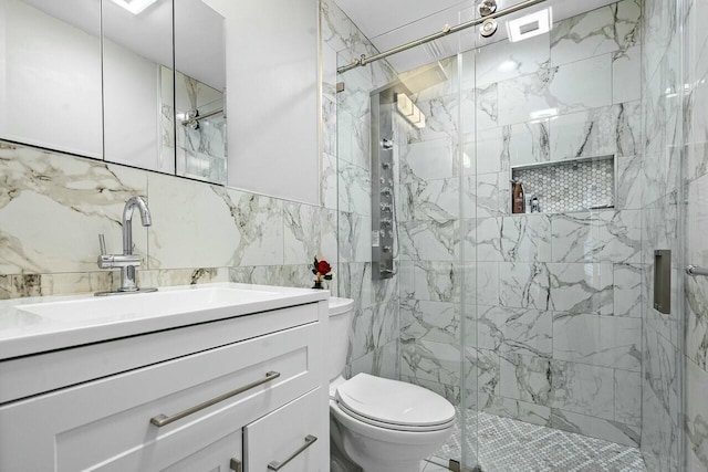 bathroom with toilet, tile walls, vanity, and a shower with shower door