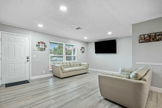 living room with light hardwood / wood-style flooring and a textured ceiling