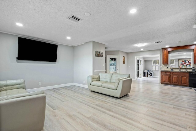 living room featuring a textured ceiling and light hardwood / wood-style flooring