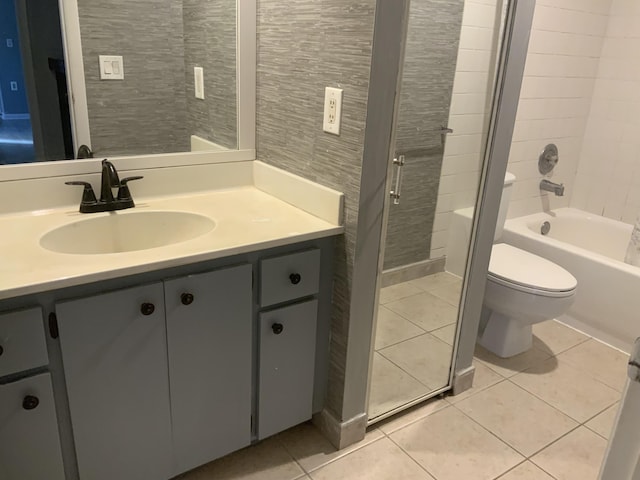 full bathroom with vanity, tiled shower / bath, tile patterned floors, and toilet