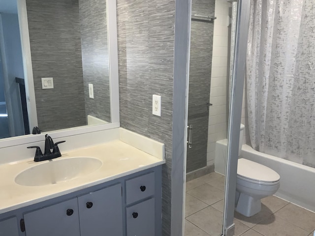 full bathroom featuring toilet, tile walls, vanity, shower / bath combination with curtain, and tile patterned flooring