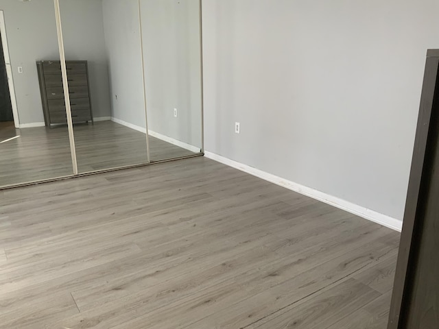 unfurnished bedroom with a closet and light hardwood / wood-style flooring