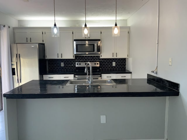 kitchen featuring appliances with stainless steel finishes, decorative light fixtures, decorative backsplash, and white cabinets