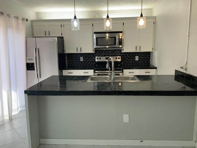 kitchen with pendant lighting, sink, appliances with stainless steel finishes, backsplash, and white cabinets