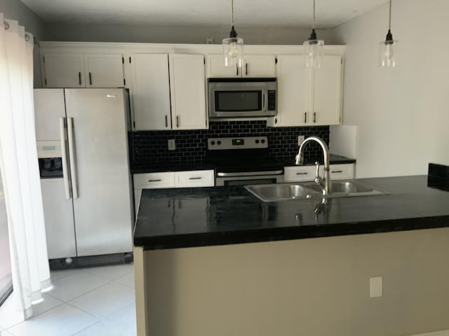 kitchen with white cabinetry, sink, stainless steel appliances, and hanging light fixtures